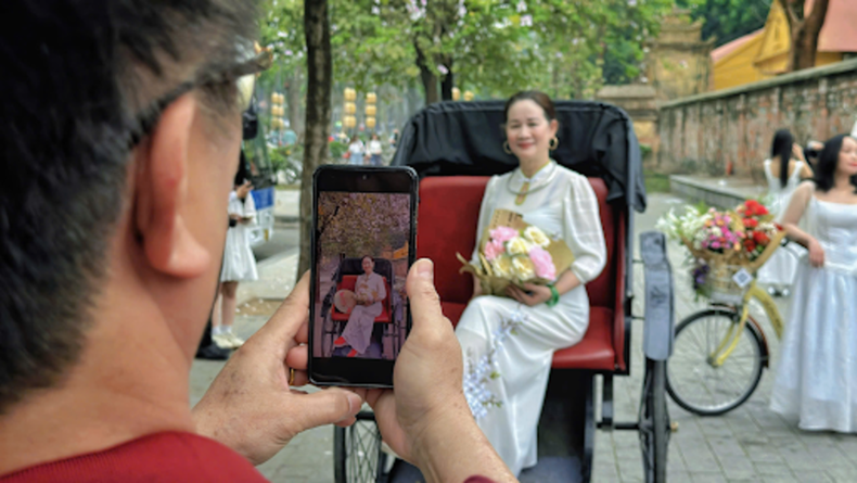 为满足游客拍照需求,洋紫荆花大道沿线的道具租赁服务也日渐兴起。鲜花装饰的自行车租赁费约1万越盾/人,搭配鲜花的三轮车拍摄服务约2万越盾/人。 为满足游客拍照需求,洋紫荆花大道沿线的道具租赁服务也日渐兴起。鲜花装饰的自行车租赁费约1万越盾/人,搭配鲜花的三轮车拍摄服务约2万越盾/人。