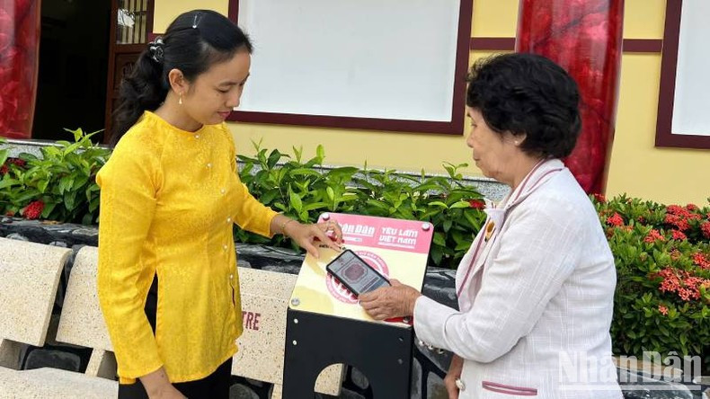 阮氏定纪念区的工作人员正在指导游客如何通过手机连接配备 NFC 芯片的智能交互信息牌。