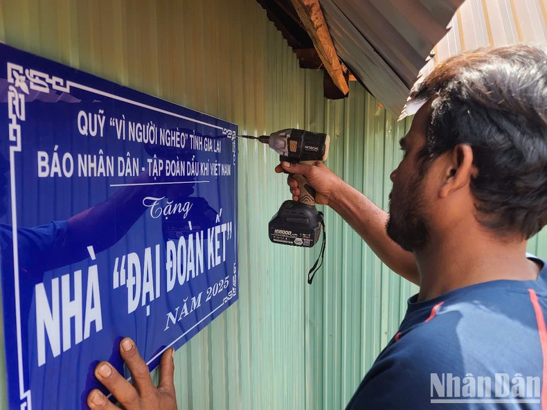 村民们高兴地悬挂标牌,准备迎接全新的生活。 村民们高兴地悬挂标牌,准备迎接全新的生活。