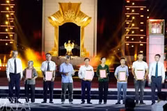 越共中央总书记、国家主席苏林（左一）和政府总理黎明兴（右一）在河内会场向烈士亲属颁发DNA鉴定结果证书。（图片来源：越通社）
