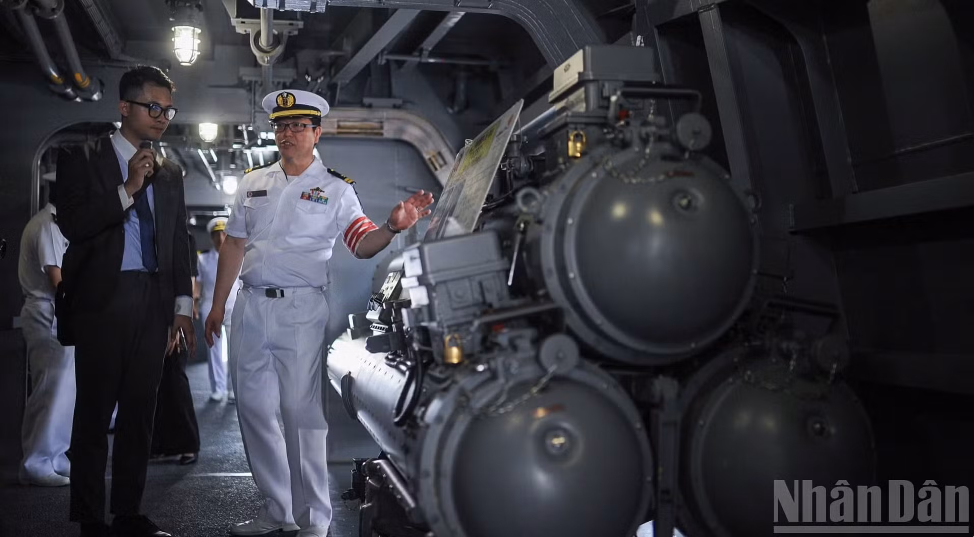 舰上军官介绍日本海上自卫队“朝日”号护卫舰上的反潜鱼雷发射系统。