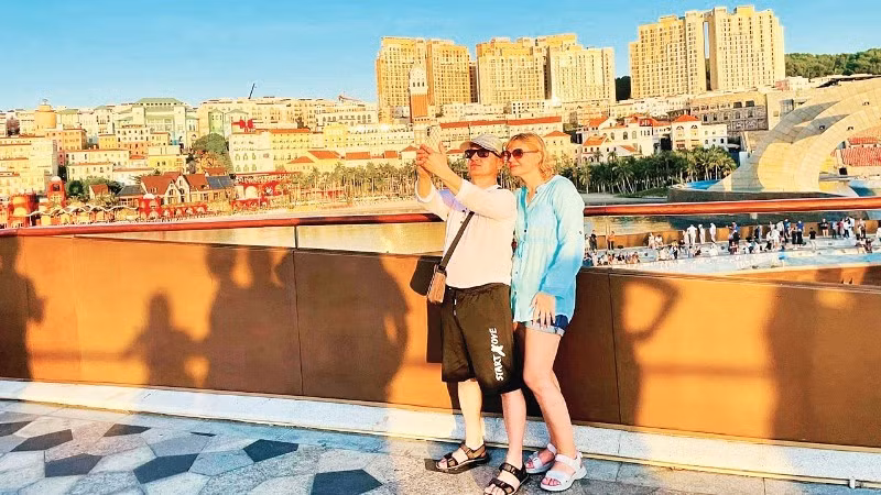 国际游客在安江省富国岛“接吻桥”打卡留影。