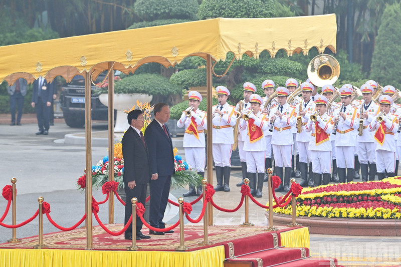 越共中央总书记苏林与老挝人民革命党中央总书记、老挝人民民主共和国主席通伦·西苏里登上检阅台。
