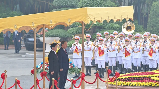 越共中央总书记苏林与老挝人民革命党中央总书记、老挝人民民主共和国主席通伦·西苏里登上检阅台。