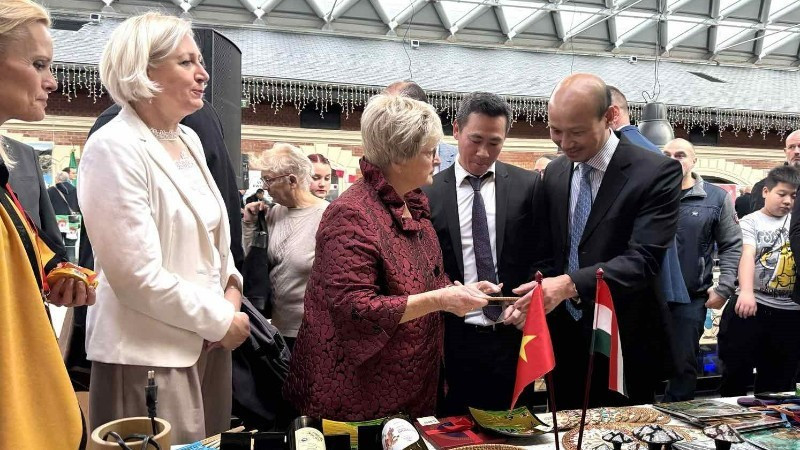 越南驻匈牙利大使裴黎泰向来宾介绍在义卖活动上展出的越南产品。（图片来源：越南驻匈牙利大使馆）