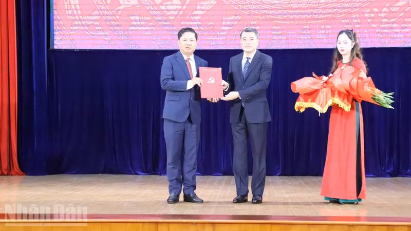 越共中央组织部部长黎明兴向梁阮明哲同志授予任免决定书。（图片来源：人民报）