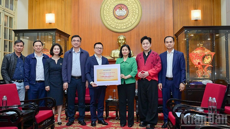 《人民报》社总编辑黎国明移交援助灾区同胞的善款。（宝龙 摄）