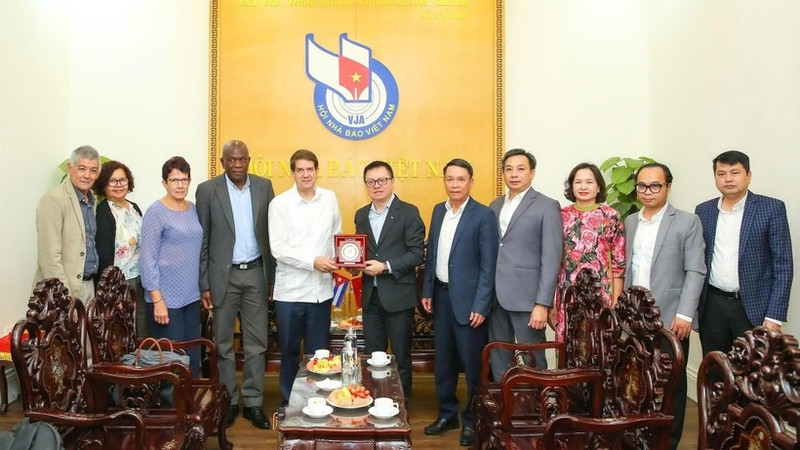 《人民报》社总编辑、越南新闻工作者协会主席黎国明与古巴拉美通讯社社长豪尔赫·莱加诺亚·阿隆索及代表团成员合影。（山海 摄）