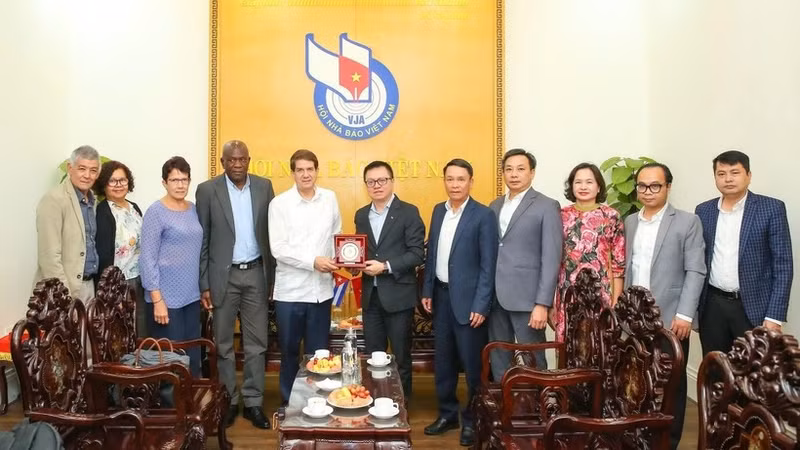 《人民报》社总编辑、越南新闻工作者协会主席黎国明与古巴拉美通讯社社长豪尔赫·莱加诺亚·阿隆索及代表团成员合影。（山海 摄）