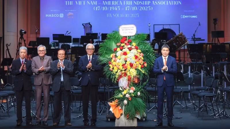 越南友好组织联合会主席潘英山（右一）向越美友好协会送花表示祝贺。（孟阮 摄）