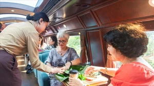 游客体验“河内五城门”旅游列车的服务。（图片来源：越通社）