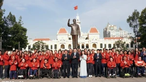 越南政府副总理梅文正与胡志明市各部委、机构代表以及越南残疾人体育代表团在胡志明主席纪念公园合影。（图片来源：越通社）