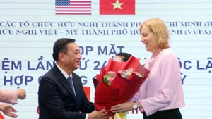 范成坚先生向美国驻胡志明市总领事苏珊·伯恩斯献花祝贺。（图片来源：越通社）