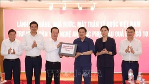 越共中央政治局委员、中央书记处书记、中央内政部部长潘廷镯向义安省人民移交党、国家、越南祖国阵线领导的援助物资。（图片来源：越通社）