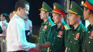 越共中央委员、同奈省委书记、同奈省国会代表团团长武宏文向边防部队战士们赠送礼物。