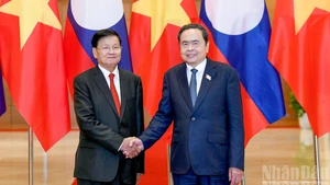 越南国会主席陈青敏与老挝人民革命党中央总书记、国家主席通伦·西苏里亲切握手。