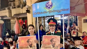 执勤人员和志愿者们高兴地领取《人民报》纪念9·2国庆特别副刊。