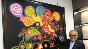 萨尔瓦多驻越南大使鲁本·奥马尔·奥罗斯科·布尔戈斯向各位代表介绍绘画作品。