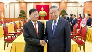 越共中央总书记苏林与老挝人民革命党中央总书记、国家主席通伦·西苏里亲切握手合影。