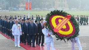代表团敬献胡志明主席的花圈上的飘带写着：“越南共产党第十四次全国代表大会——永远铭记伟大的胡志明主席”。