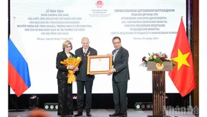 越南驻俄罗斯大使邓明魁向俄罗斯联邦委员会预算与金融市场委员会主席、卡卢加州前州长长阿纳托利·阿尔塔莫诺夫授予友谊勋章。（春兴 摄）