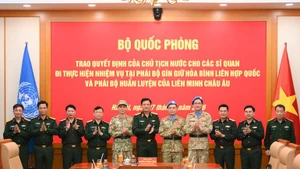 阮长胜上将与两名参加维和任务的军官和各位代表合影。