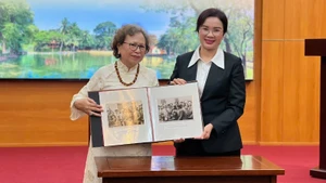 胡志明主席遗迹区代表接收由原公安部管理局副局长黎芳一家赠送的珍贵纪实照片。