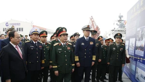 两位部长参观两国海军联合巡逻图片展。