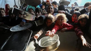 2026年3月15日，巴勒斯坦人在加沙地带北部拜特拉希亚的一个难民营领取免费食物。（图片：新华社）