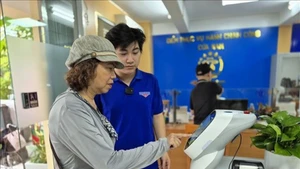 市民使用人工智能机器人来办理行政手续。（图片来源：越通社）