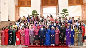 越南政府总理范明正与各位女性外交官代表合影。（陈海 摄）