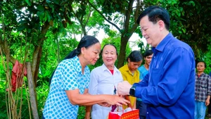 梅文正副总理向受暴雨洪水影响的民众赠送慰问品。（图片来源：清化省报）
