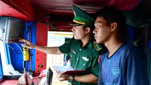 执法力量登船检查渔船。（图片来源：越通社）