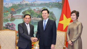 越南政府副总理梅文正会见老挝巴特寮通讯社（KPL）社长万纳辛·西马冯。（图片来源：越通社）