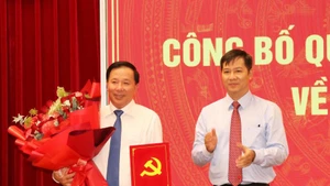 越共中央委员、中央组织部副部长阮成心向阮文幼同志颁授越共中央书记处的决定。（图片来源：越通社）