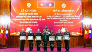 老挝国防部副部长、老挝人民军总政治局主任冯松•英潘平上将向越南108中央军队医院的个人授予老挝国家的劳动勋章。（图片来源：越通社）