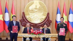 越共中央总书记苏林与老挝人民革命党中央总书记、国家主席通伦共同见证越南公安部与老挝国防部关于建设越老友谊道路项目的备忘录交换仪式。（图片来源：越通社）