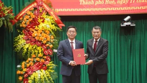 中央组织部部长黎明兴向阮廷忠同志颁发决定书。（图片来源：VGP）
