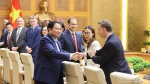 范明正总理与英国企业领导代表亲切握手。（陈海 摄）