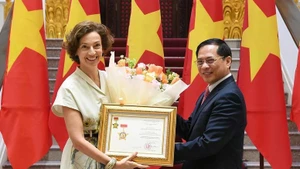 越南政府副总理兼外交部长裴青山向联合国教科文组织总干事奥德蕾·阿祖莱授予“致力于越南外交事业”纪念章。（图片来源：越通社）