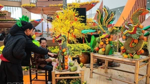 众多市民前来参观了解艺术家阮文线（胡志明市）创作的果蔬艺术雕刻作品。（图片来源：越通社）