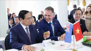 越南政府总理范明正了解新西兰植物与食品研究所的产品（奥克兰，2024年3月10日）。（图片来源：越通社）