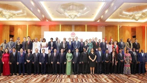 国家主席梁强与夫人出席越安建交50周年纪念活动，与各位代表合影。（图片来源：越通社）
