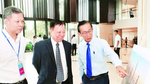 与会代表参观胡志明市国际金融中心模拟图片展。（黄朝 摄）