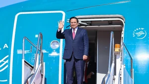 越南政府总理范明正抵达万象。（图片来源：VGP）