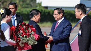 越南政府总理范明正抵达万象。（图片来源：VGP）