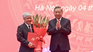 苏林总书记向杜文战同志颁发决定书并送花祝贺。