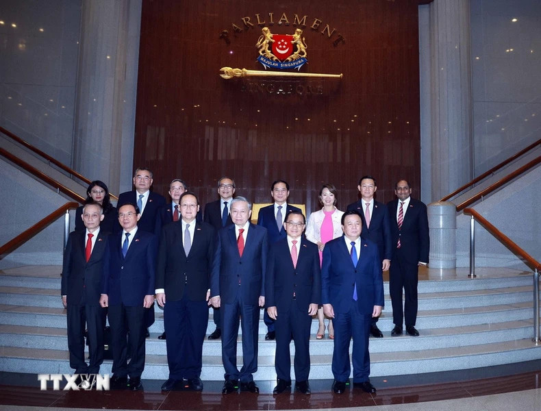 越共中央总书记苏林与新加坡国会议长谢健平和各位代表合影。