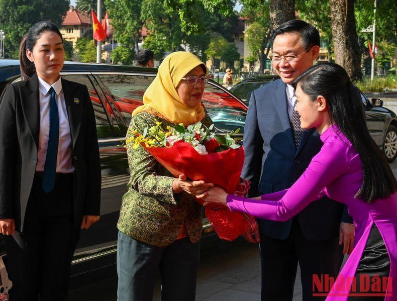 越南国会办公厅人员向新加坡总统哈莉玛·雅各布赠送鲜花。