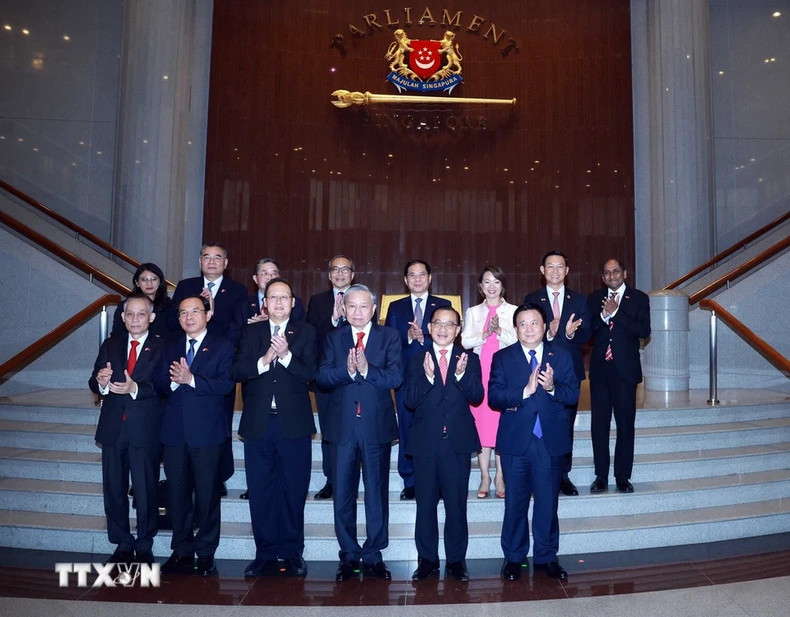 越共中央总书记苏林与新加坡国会议长谢健平和各位代表合影。
